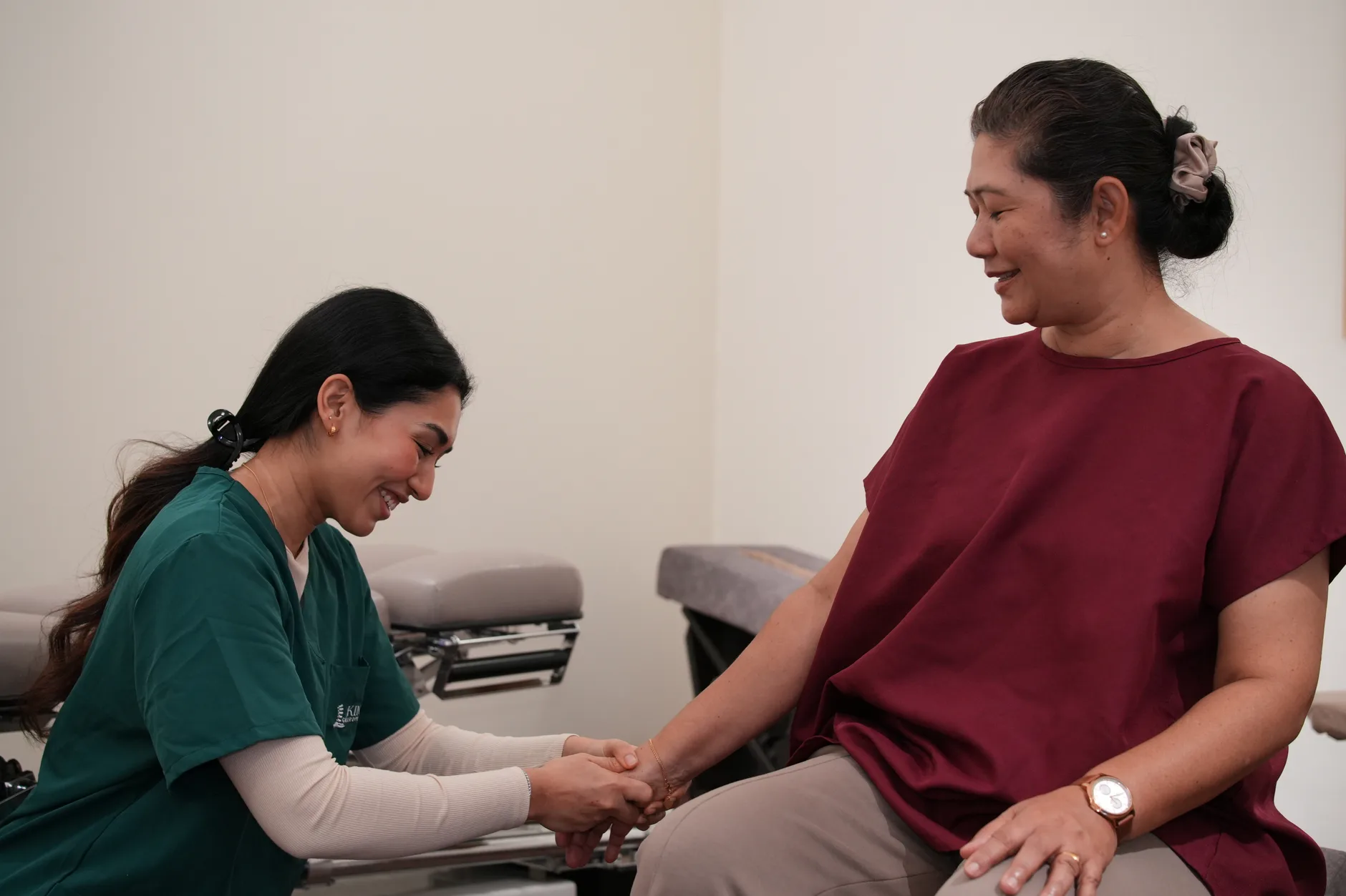 Kind Chiropractic chiropractor speaking with a smiling patient during a consultation