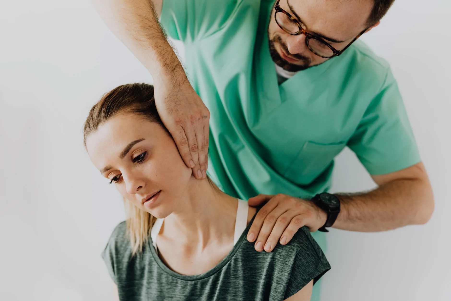 Chiropractor gently assessing and treating a patient's neck during a session