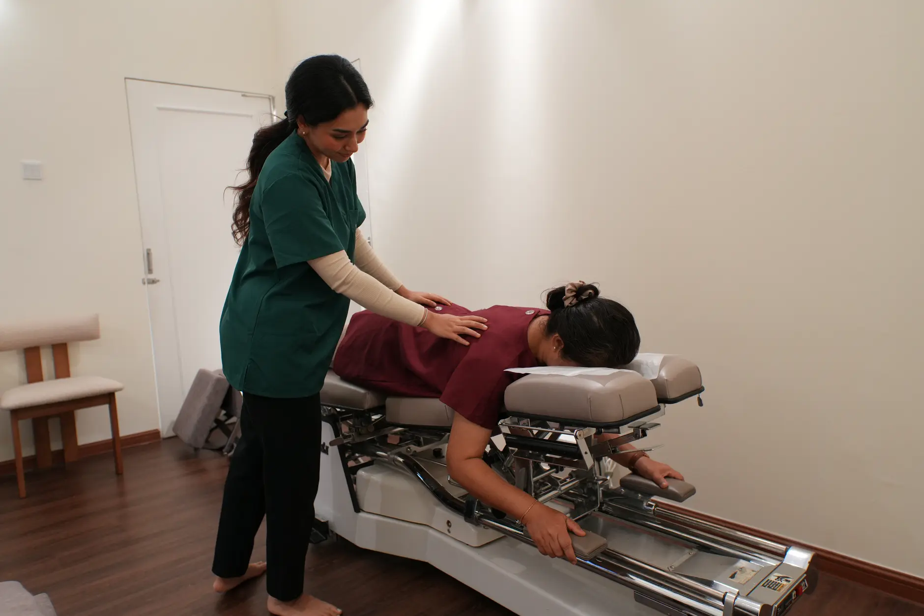 Patient receiving careful spinal adjustment for lower back disc pain at a chiropractic clinic