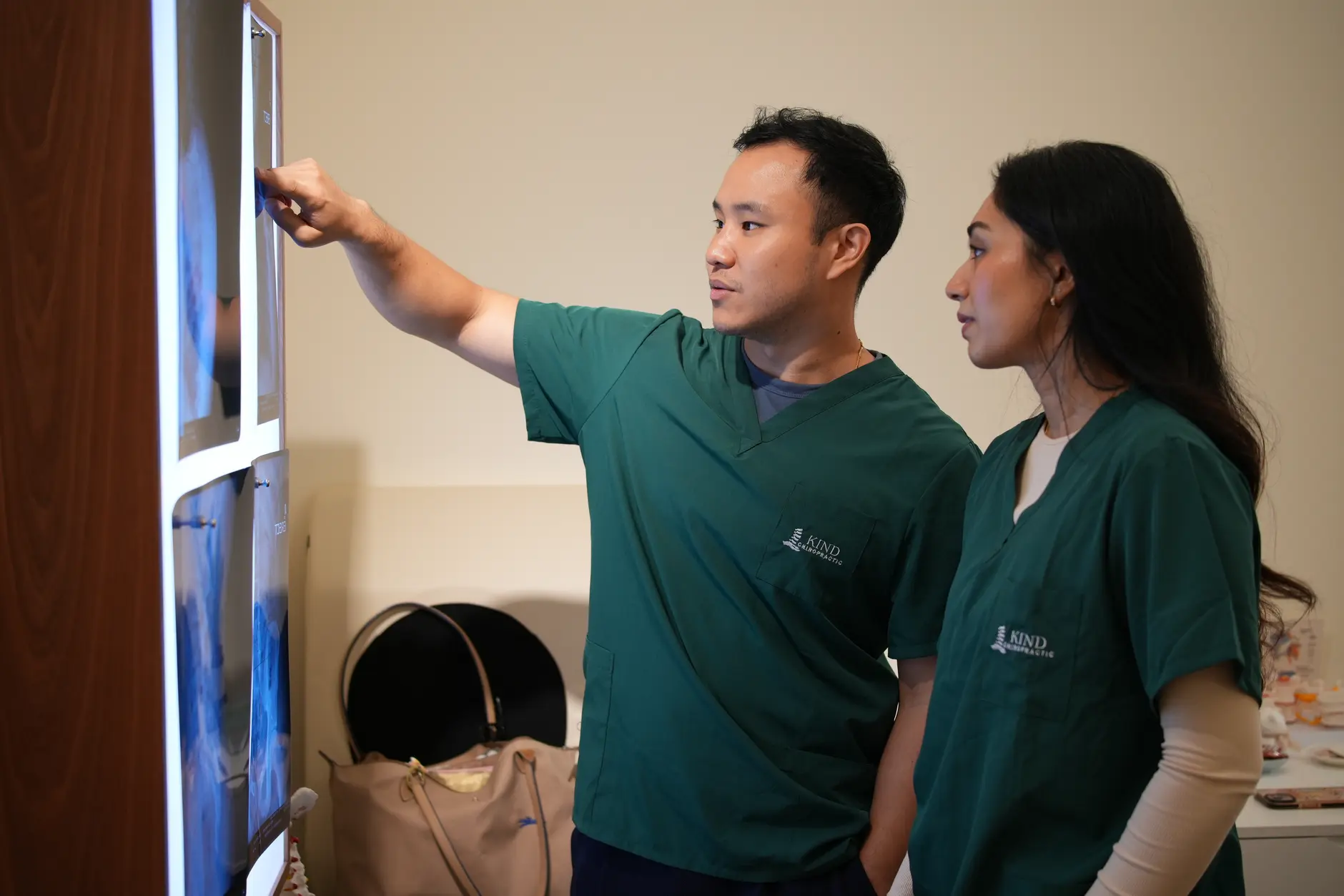 Chiropractor reviewing posture and lower back alignment with a patient at Kind Chiropractic Kuala Lumpur